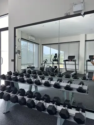 a gym with a large mirror and rows of exercise equipment at Title Halo Holi Day 40m2 King Bed Pool View in Nai Yang Beach