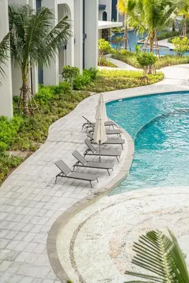 a swimming pool with lounge chairs and an umbrella at Title Halo Holi Day 40m2 King Bed Pool View in Nai Yang Beach