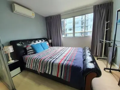 a bedroom with a bed with a couch and a window at Dcondo Kathu Poolview by LaChambre Phuket in Phuket Town