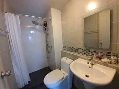 a bathroom with a toilet and a sink and a mirror at Dcondo Kathu Poolview by LaChambre Phuket in Phuket Town