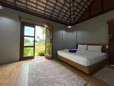 a bedroom with a bed and a large window at Rawi Seaside Cottage, Ko Yao Noi in Ban Laem Sai