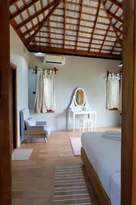 a bedroom with a bed and a table and a chair at Rawi Seaside Cottage, Ko Yao Noi in Ban Laem Sai