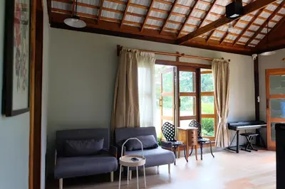 a living room with a couch and a piano at Rawi Seaside Cottage, Ko Yao Noi in Ban Laem Sai
