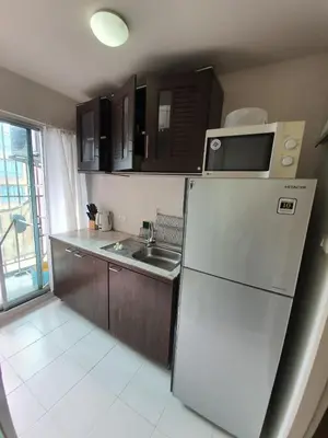 a small kitchen with a refrigerator and a sink at Dcondo Creek Poolview by Lachambre Phuket in Phuket Town
