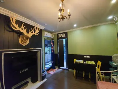 a living room with a fireplace and a dining room at Dcondo Creek Poolview by Lachambre Phuket in Phuket Town
