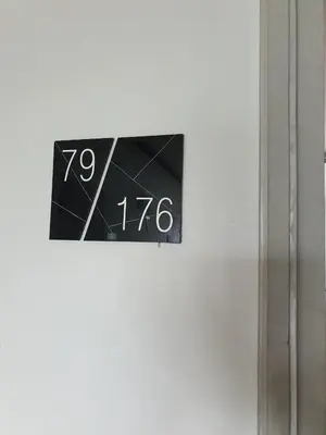 a clock on the side of a white wall at Dcondo Creek Poolview by Lachambre Phuket in Phuket Town