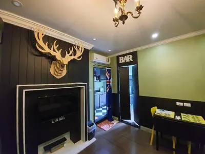 a living room with a fireplace and a table and a chandelier at Dcondo Creek Poolview by Lachambre Phuket in Phuket Town