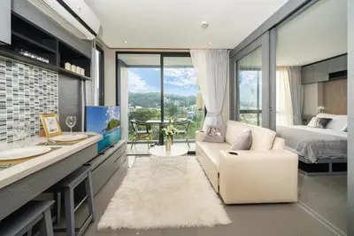 a living room with a white couch and a bed at Apartment 1 - bedroom Kamala in Kamala Beach