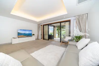 a living room with a white couch and a tv at Apartment 1 - bedroom Kamala in Kamala Beach