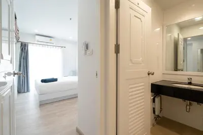 a white bathroom with a sink and a bedroom at Phuket Villa 1 bedroom apartment in Patong in Patong Beach