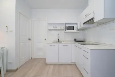 a white kitchen with a sink and a microwave at Phuket Villa 1 bedroom apartment in Patong in Patong Beach