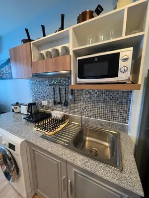 a kitchen with a sink and a microwave at zcape 2 boat avenue 2 bedroom by sahana in Ban Thalat Choeng Thale