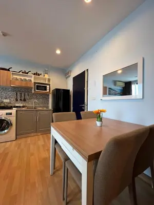 a kitchen and dining room with a wooden table and chairs at zcape 2 boat avenue 2 bedroom by sahana in Ban Thalat Choeng Thale