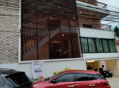 a red car parked in front of a building at Thebirdhouse Patong Phuket 301 in Patong Beach