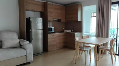 a kitchen with a table and a stainless steel refrigerator at Thebirdhouse Patong Phuket 301 in Patong Beach