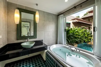 a bathroom with a tub and a sink and a window at Prima Karon Villa in Karon Beach
