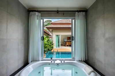 a bath tub in a bathroom with a window at Prima Karon Villa in Karon Beach