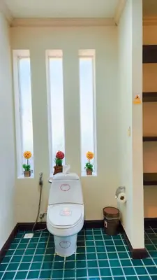 a bathroom with a toilet with three windows at Prima Karon Villa in Karon Beach