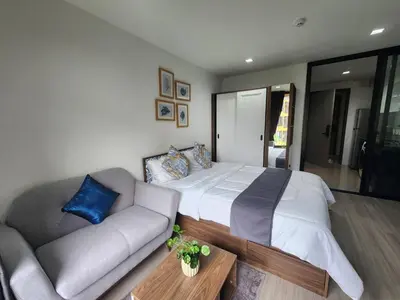 a bedroom with a large bed and a couch at The Base Central Phuket-C54BS in Phuket Town