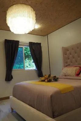 a bedroom with a bed and a window and a chandelier at Villa Omloft in Changwat Phuket