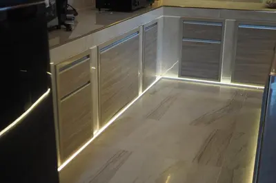 a kitchen with wooden cabinets with lights on the floor at Villa Omloft in Changwat Phuket