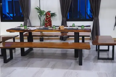 a dining room table with benches and a christmas tree at Villa Omloft in Changwat Phuket