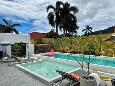 a swimming pool with chairs and a pink float in a house at Dolce Vita Villa Memory Bang-Tao Phuket in Ban Thalat Choeng Thale