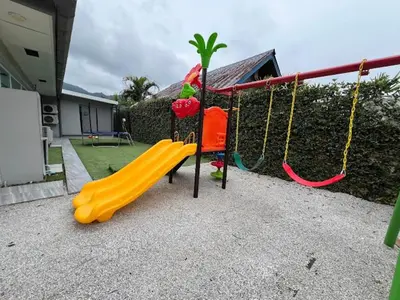 a playground with a yellow slide and a swing at Dolce Vita Villa Memory Bang-Tao Phuket in Ban Thalat Choeng Thale
