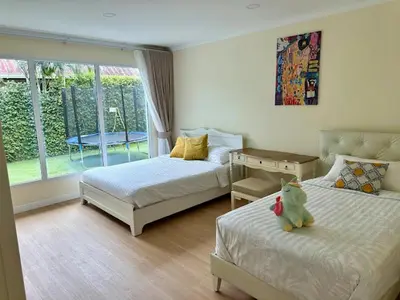 a bedroom with two beds and a teddy bear sitting on the bed at Dolce Vita Villa Memory Bang-Tao Phuket in Ban Thalat Choeng Thale