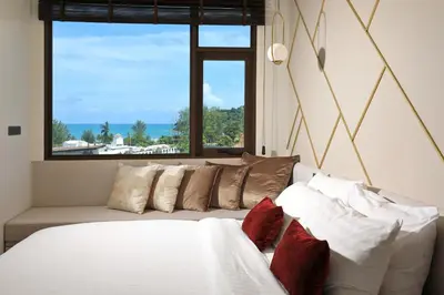 a bedroom with a couch and a large window at Seaview 1bdr apartment Karon PRO-613 in Karon Beach