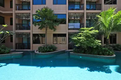 a swimming pool in front of a building with palm trees at Seaview 1bdr apartment Karon PRO-613 in Karon Beach