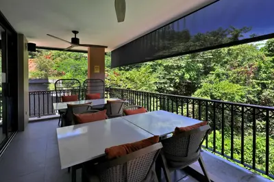 a patio with tables and chairs on a balcony at Seaview 1bdr apartment Karon PRO-613 in Karon Beach