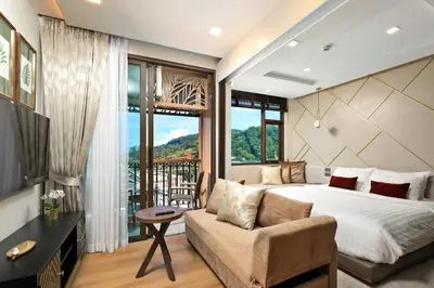 a bedroom with a bed and a couch and a window at Seaview 1bdr apartment Karon PRO-613 in Karon Beach