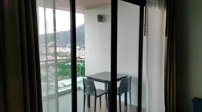a table and two chairs in a room with a window at Thebirdhouse Patong Phuket 302 in Patong Beach