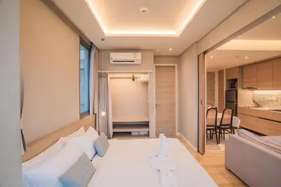 a room with a white bed and a kitchen at The Paradise sea view apartment in Krabi town