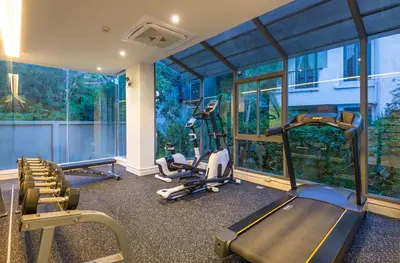 a gym with treadmills and ellipticals in a room with windows at The Paradise sea view apartment in Krabi town