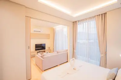 a white bedroom with a large window and a couch at The Paradise sea view apartment in Krabi town