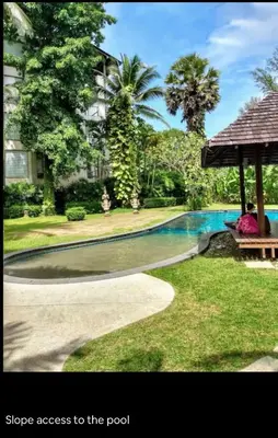 a swimming pool in front of a house at casuarina shores penthouse in Bang Tao Beach