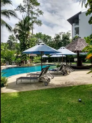 a group of chairs and umbrellas next to a pool at casuarina shores penthouse in Bang Tao Beach