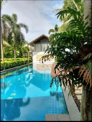 a large blue swimming pool with a house at casuarina shores penthouse in Bang Tao Beach