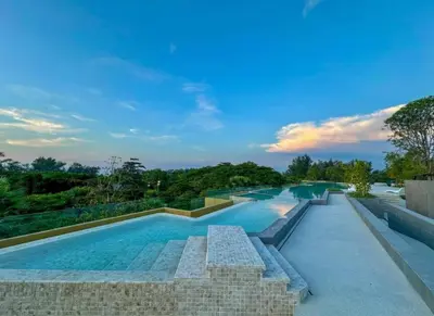a large swimming pool with a brick wall and trees at Laguna BeachSide 200m to beach BangTao in Bang Tao Beach