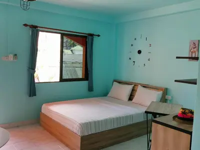 a bedroom with a bed with blue walls and a window at myPatong Social Hostel in Patong Beach