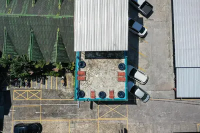 an overhead view of a swimming pool with cars and trees at myPatong Social Hostel in Patong Beach