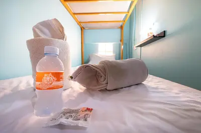 a bottle of water and a towel on a bed at myPatong Social Hostel in Patong Beach