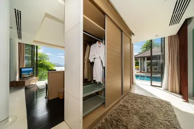 a walk in closet in a home with a view of the pool at Exclusive Oceanfront Living, 5BR Pool Villa Elegance in Ko Lek