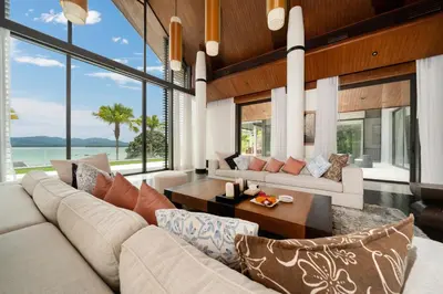 a living room with a couch and a table at Exclusive Oceanfront Living, 5BR Pool Villa Elegance in Ko Lek