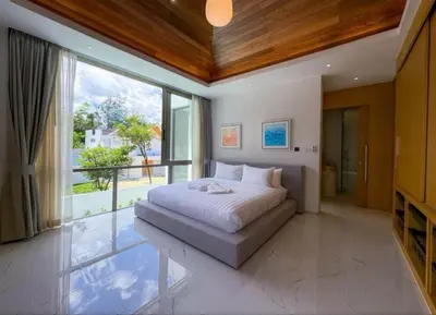 a bedroom with a bed and a large window at Ola-Villa in Kamala Beach