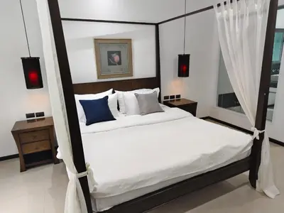 a bedroom with a canopy bed with white and blue pillows at Oxygen Villa 3 beds in Rawai Beach