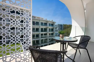 a balcony with a table and chairs and a building at Private Pool View 1BR Apartment in Naiharn Residence near Beach, UTN D502 in Rawai Beach