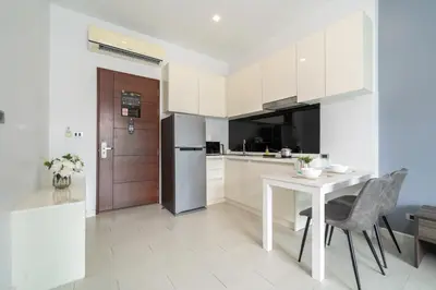 a white kitchen with a table and a refrigerator at Private Pool View 1BR Apartment in Naiharn Residence near Beach, UTN D502 in Rawai Beach